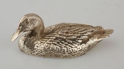 a silver duck that is sitting on a white surface