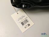 a black purse with a price tag attached to it