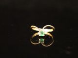 a gold ring with an emerald stone in the middle of it