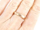 a woman ' s hand with a gold ring on it