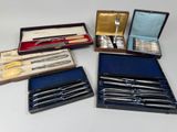 plusieurs types d'argenterie dans un coffret posé sur une table