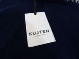 a close up of a blue sweater with a white tag on it