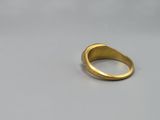 a close up of a gold ring on a white surface