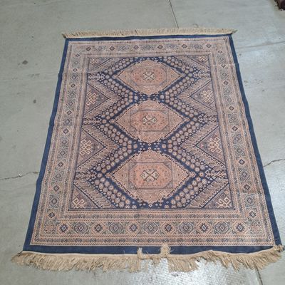 Le tapis au sol est bleu et beige, avec un motif en losanges