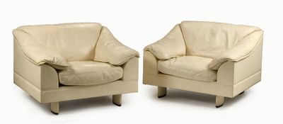 pair of cream leather chairs with arms and legs on a white background