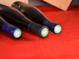 four bottles of wine are lined up on a red table