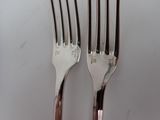 two forks that are sitting next to each other on a table