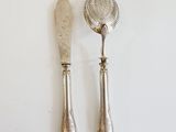 pair of silver plated serving utensils with a spoon and spoon rest