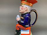 a figurine of a man sitting on a stack of books