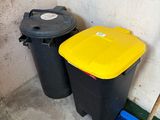 two black and yellow trash cans next to each other