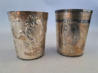 deux tasses en argent ornées de motifs, posées sur une table