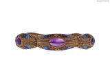 un gros plan d'une bague violette et bleue sur fond blanc