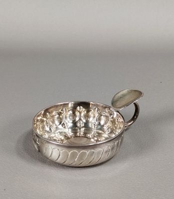 une photo représentant un bol en argent posé sur une table, avec une cuillère à l'intérieur