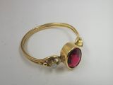 Gros plan sur une bague en or ornée d'une pierre rouge