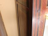 a tall wooden cabinet in the corner of a room