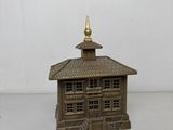 un petit bâtiment en bois au toit doré