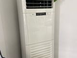 an air conditioner sitting on top of a tiled floor next to a chair