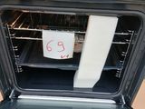 a man taking a picture of an oven with a note taped to it