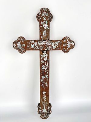 an old wooden cross with floral designs on it against a white background
