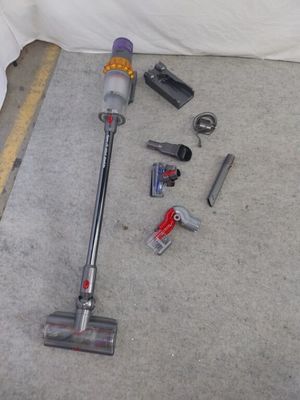 un aspirateur posé par terre à côté d'autres objets