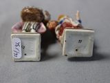 two miniature figurines that are sitting on a table