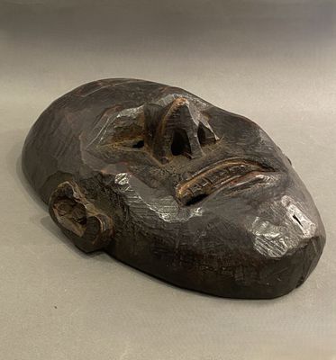 une photo d'un masque en bois posé sur une table