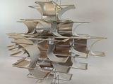 a metal sculpture of a ship on display on a white surface