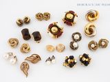 a lot of different types of earrings on a white surface