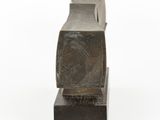 a metal object that is sitting on top of a wooden block
