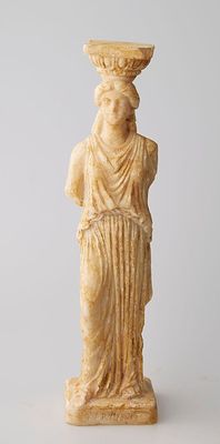 une statue représentant une femme avec un bol sur la tête