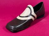 a close up of a pair of black and white shoes on a pink background