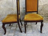 two chairs sitting next to each other on a cobblestone floor