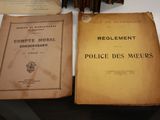Deux vieux livres sont posés sur une table, à côté d'une pile de livres