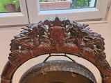 a metal gong sitting on a wooden stand in front of a window
