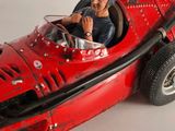 a red toy car with a man sitting in it