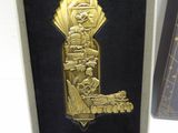 a gold medal with a picture of a man and a woman on it