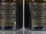 two bottles of wine are sitting next to each other on a table