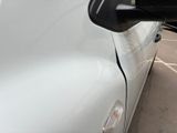 a white car parked in a parking lot next to a building