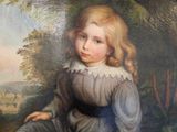 portrait of a young girl in a blue dress sitting in a wooded setting