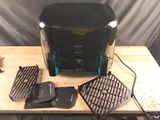 un grille-pain noir et un grill posés sur une table en bois