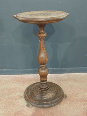 an old wooden table with a wooden top on a carpeted floor