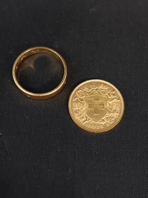un gros plan d'une pièce de monnaie et d'une bague sur une surface noire