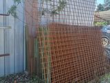 a rusted fence next to a building with a car parked in front of it