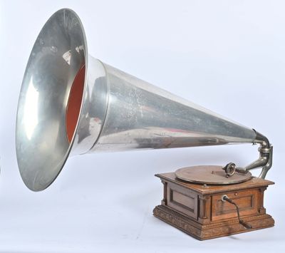 un gramophone argenté et rouge à côté d'une boîte en bois