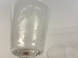 a glass that is sitting on a table next to a glass