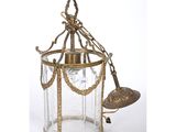 une lanterne ancienne en laiton et en verre, ornée d'une clochette, sur fond blanc