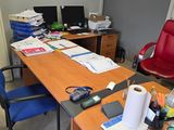 un bureau recouvert de papiers et une chaise rouge