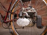 a close up view of a bicycle with a motorbike attached to it