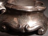 a silver bowl with a handle on a table