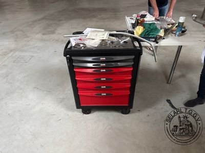a man standing next to a table with a tool box on it